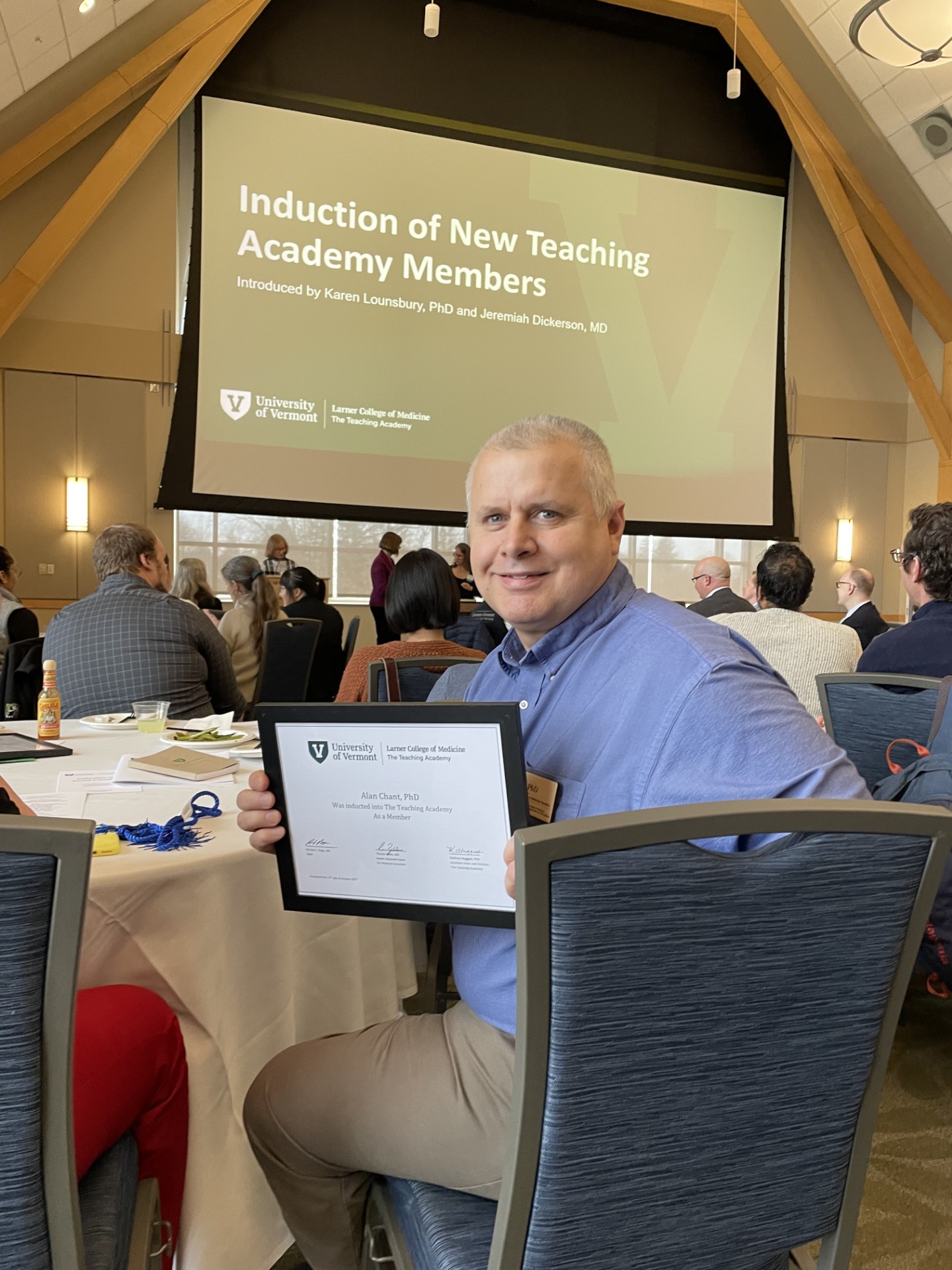 Alan Chant smiles and holds up certificate