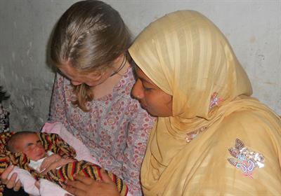 VTC Researcher in Bangladesh holding baby with mother