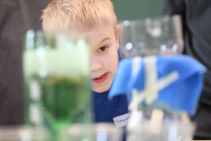 child looking at beakers with curiosity