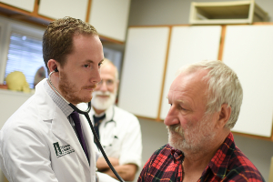 doctor listening to heartbeat of a patient