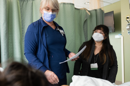 Medical student observes a nurse talking to a patient