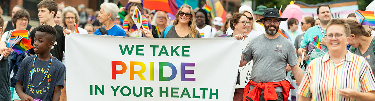 We take pride in your health banner at Pride parade.