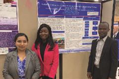 Trishnee with grad students Victoria Idehai and Pindar Mbaya standing in front of a poster at a conference